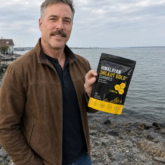 Traveler holding MENRYX Himalayan Shilajit Gold Gummies by the waterfront
